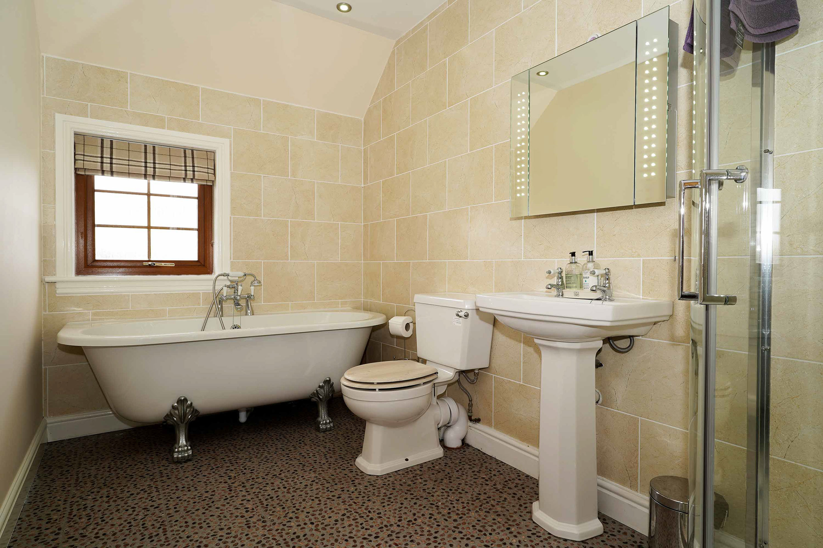 Culla Cottage Self Catering Accommodation in Benbecula contains an En Suite Bathroom with Bath Shower and a selectino of Toilitries